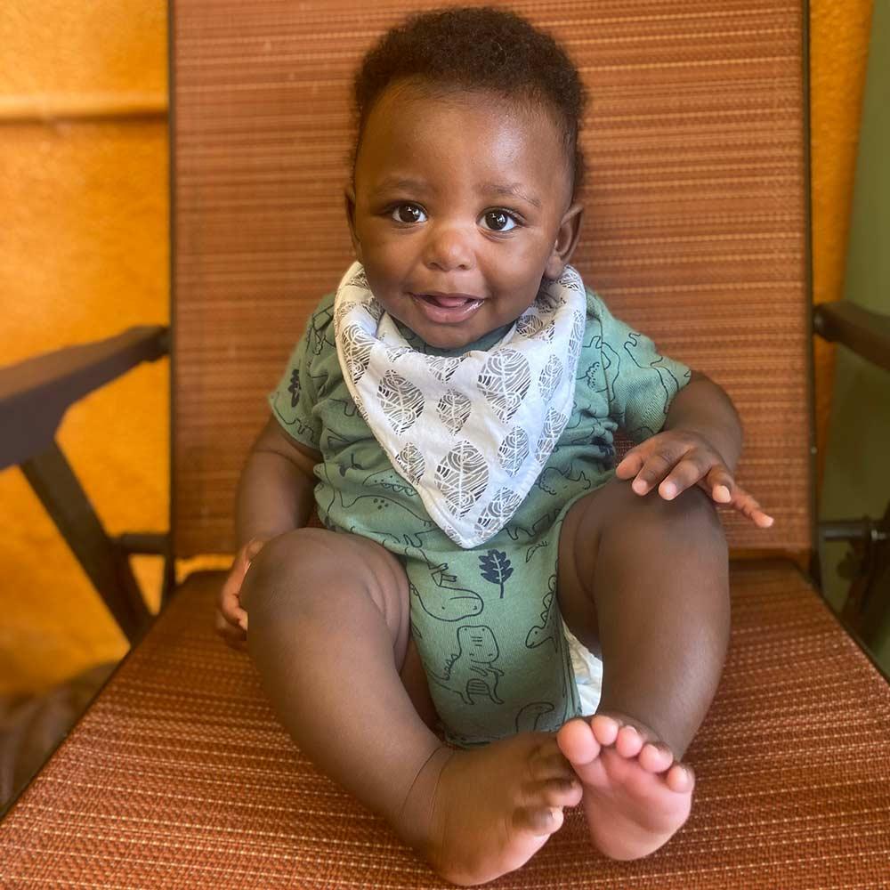 Groomer Deja Pearson's son sitting in a chair, smiling