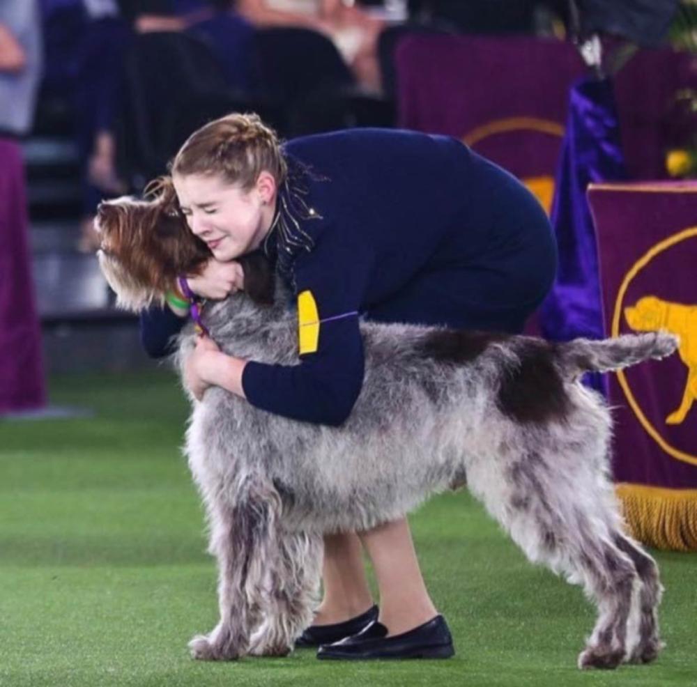 Handler snuggling her dog at 2021 Westminster Kennel Club Dog Show